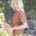 Blonde bob wig styled on a woman outdoors with greenery background.